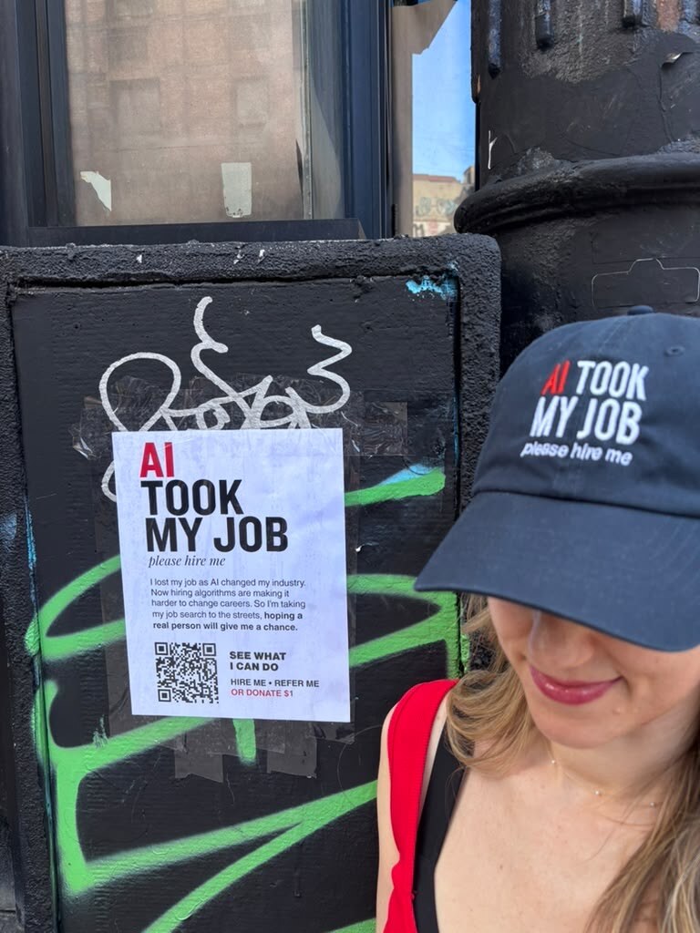 Allison wearing an AI Took My Job hat beside a campaign flyer