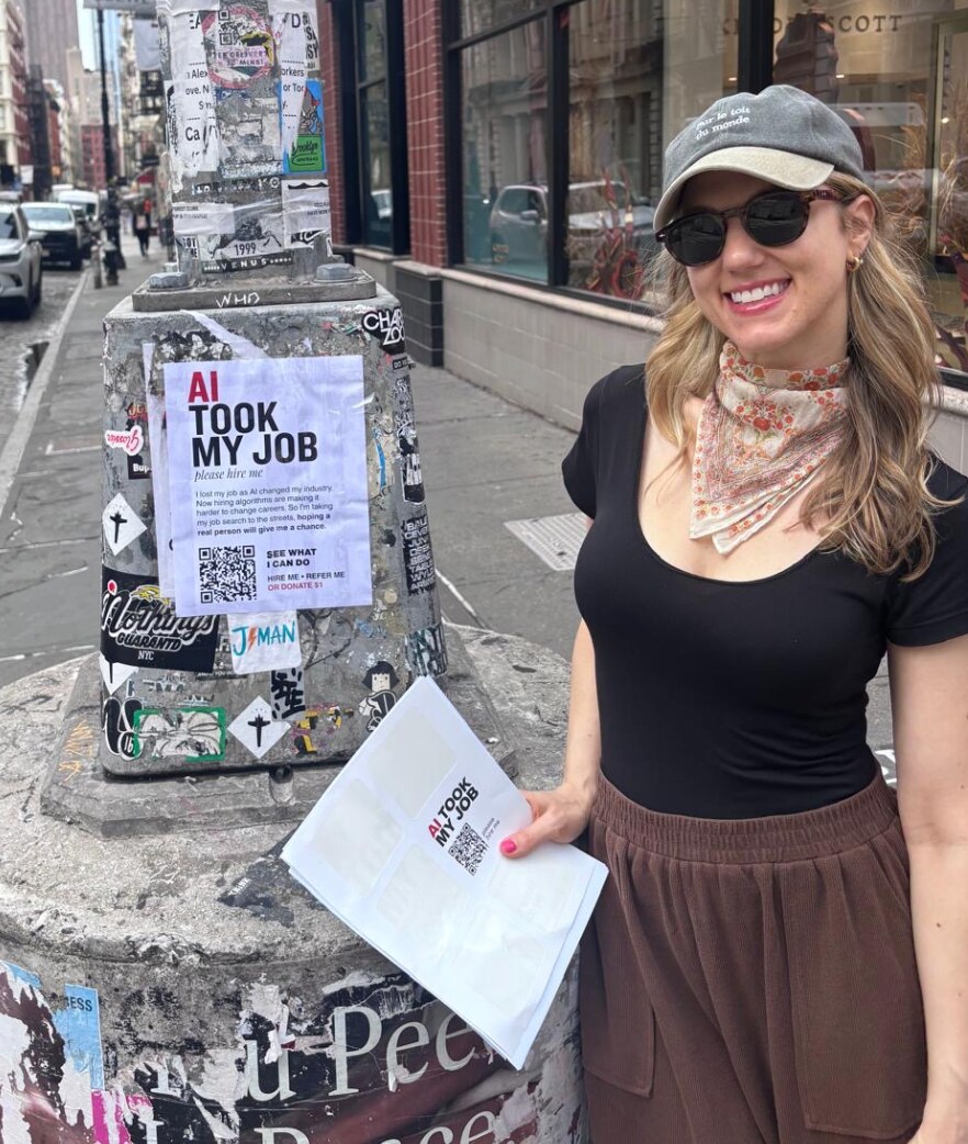 Allison standing beside an AI Took My Job flyer in New York City